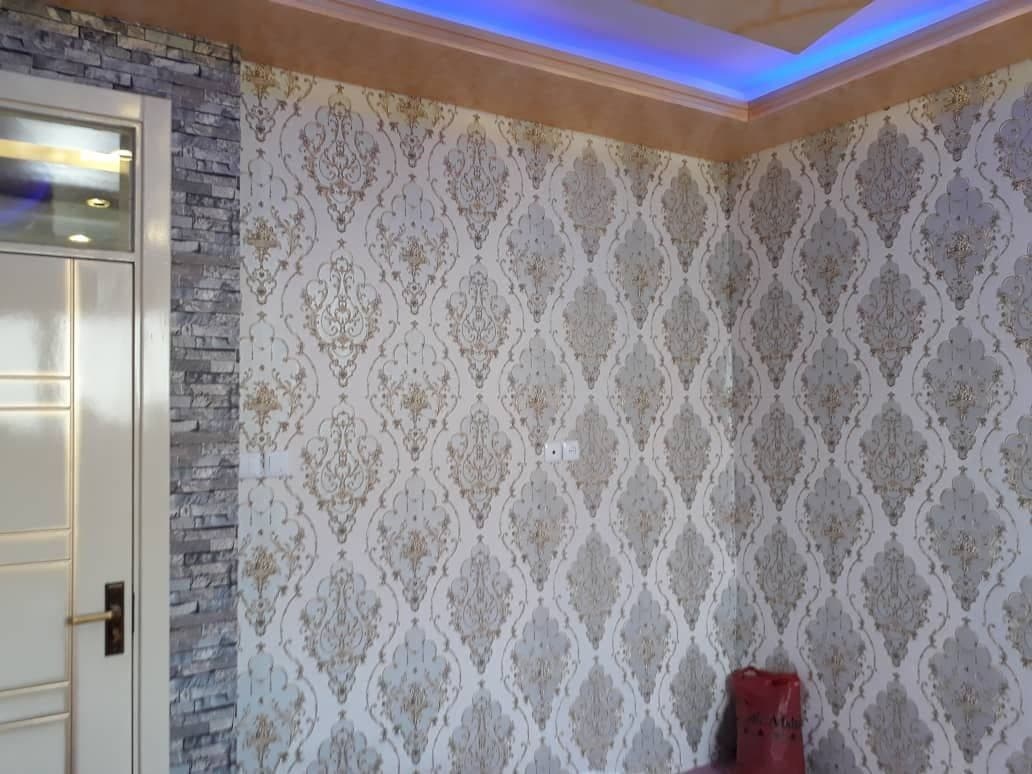 Hallway corner with damask wallpaper and brick-effect feature column