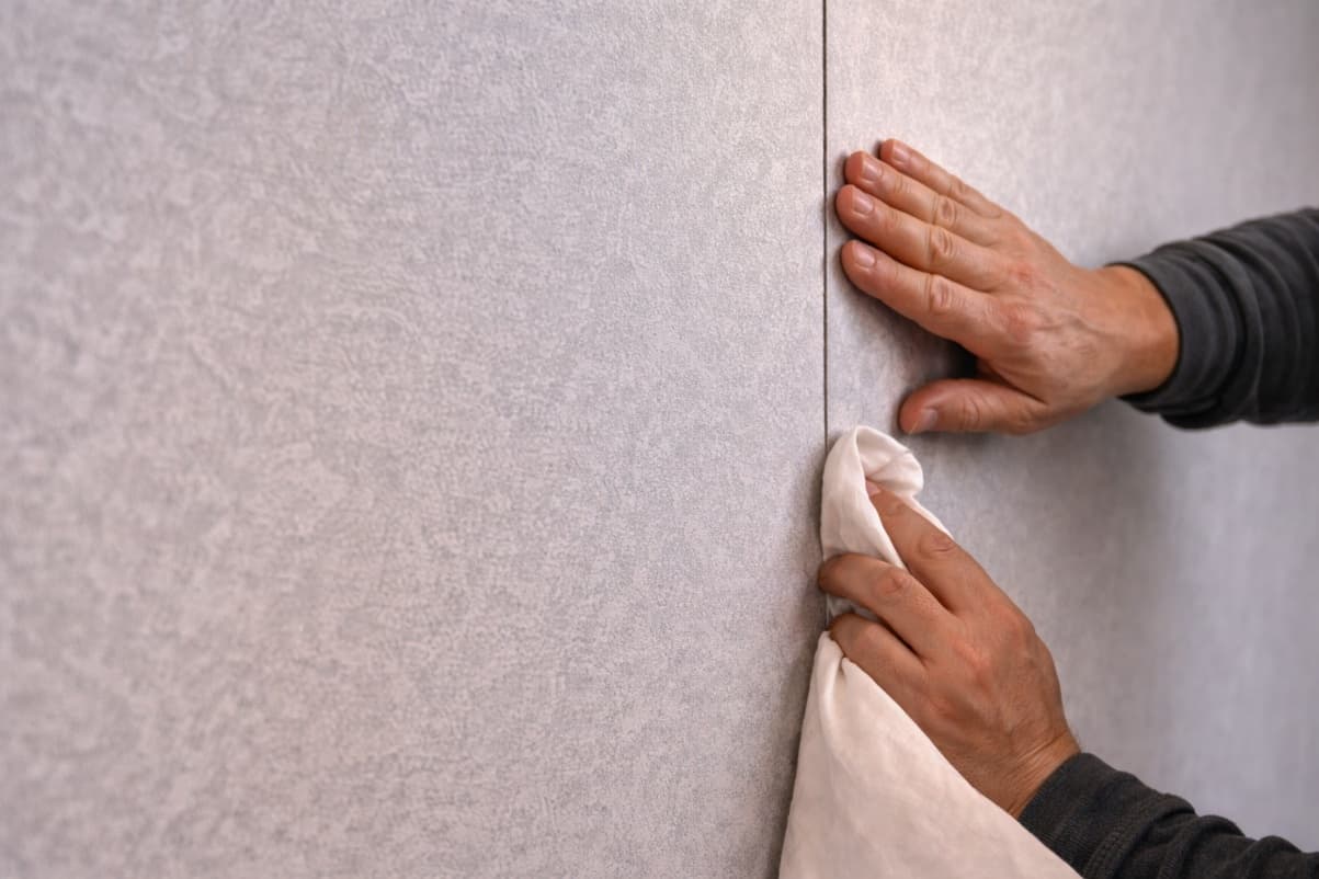 Smoothing a mural panel onto a wall during installation