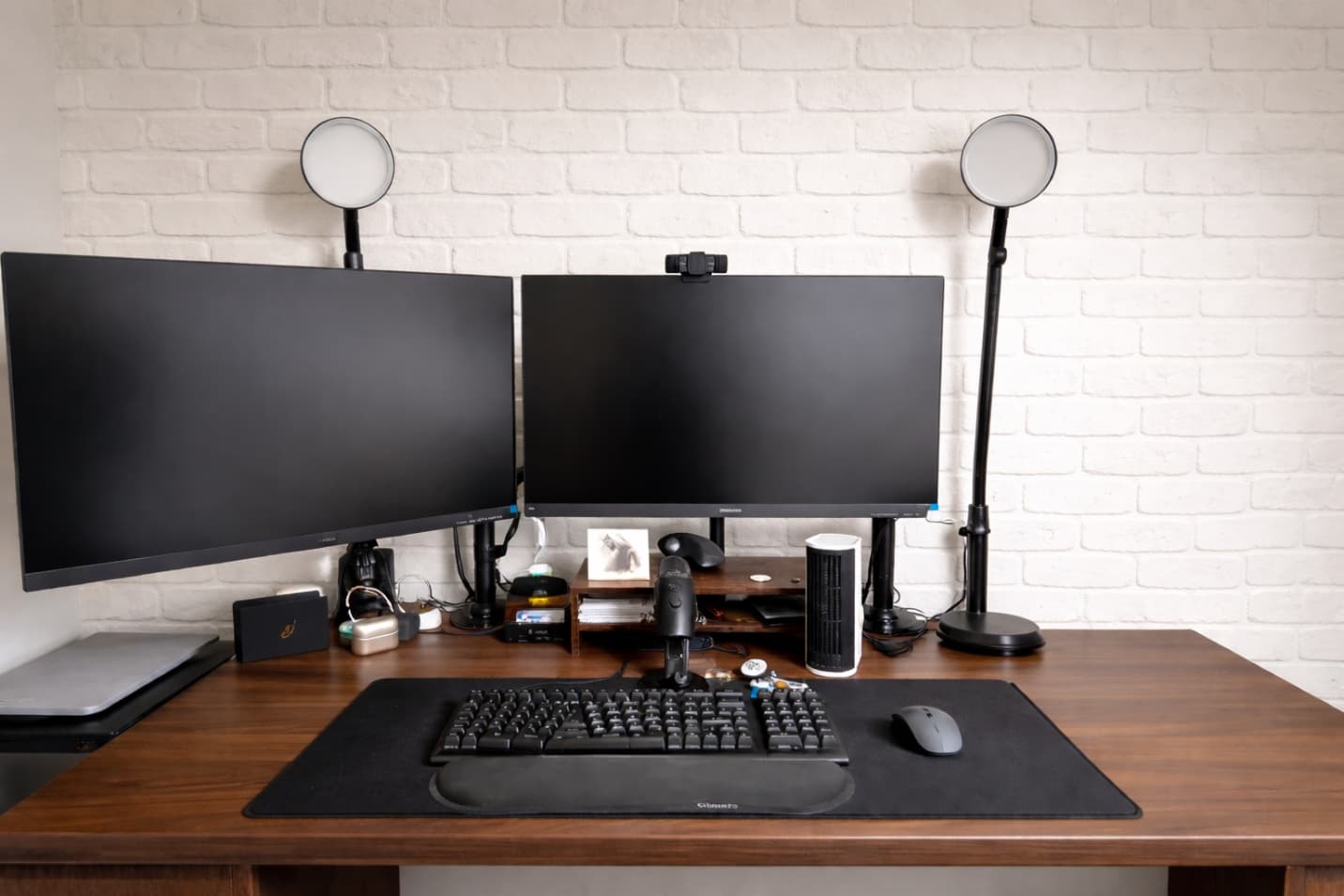 Clean modern home office with dual-monitor setup against crisp white brick wall mural